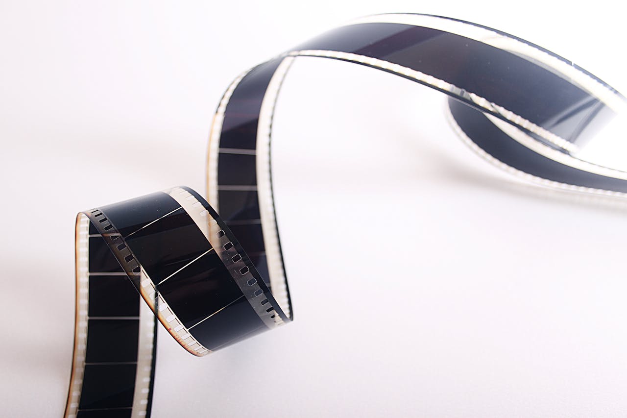 Close-up of a curled filmstrip against a white background, emphasizing vintage cinema.